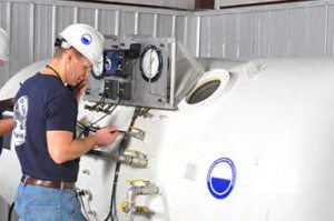 UCC A Focus On Safety Worker from Underwater Construction Corporation in a white hard hat monitoring equipment indoors.