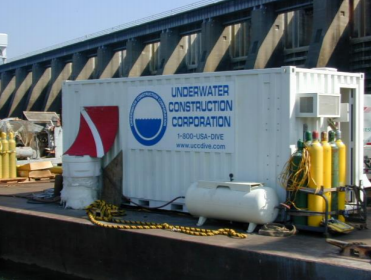 Underwater Construction Corporation mixed gas diving support container with high-pressure gas cylinders on barge.
