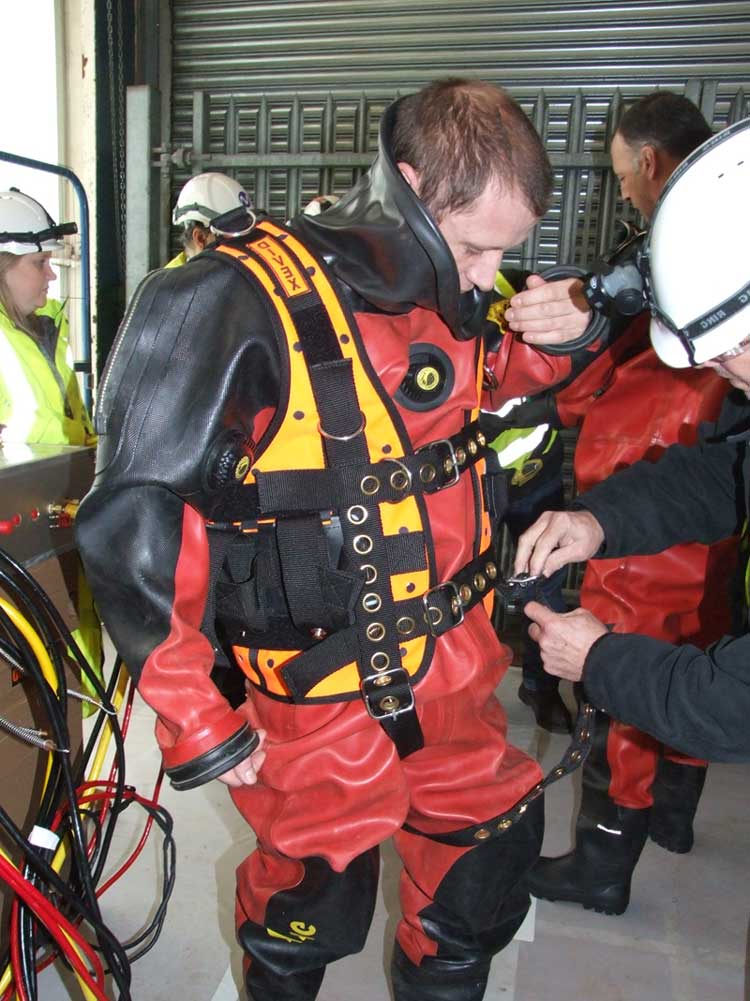 UCC commercial diver in full diving gear being assited with a safety check.